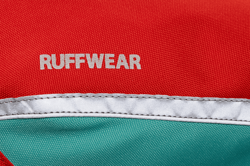 Leuchtend rote und türkise Rucksack-Tasche mit "RUFFWEAR" Schriftzug für mehr Sichtbarkeit und Sicherheit.