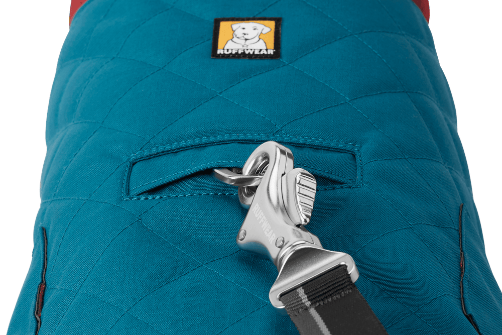 Blauer gesteppter Hundemantel von Ruffwear mit Befestigungshaken und Tasche, ideal für kalte Tage.