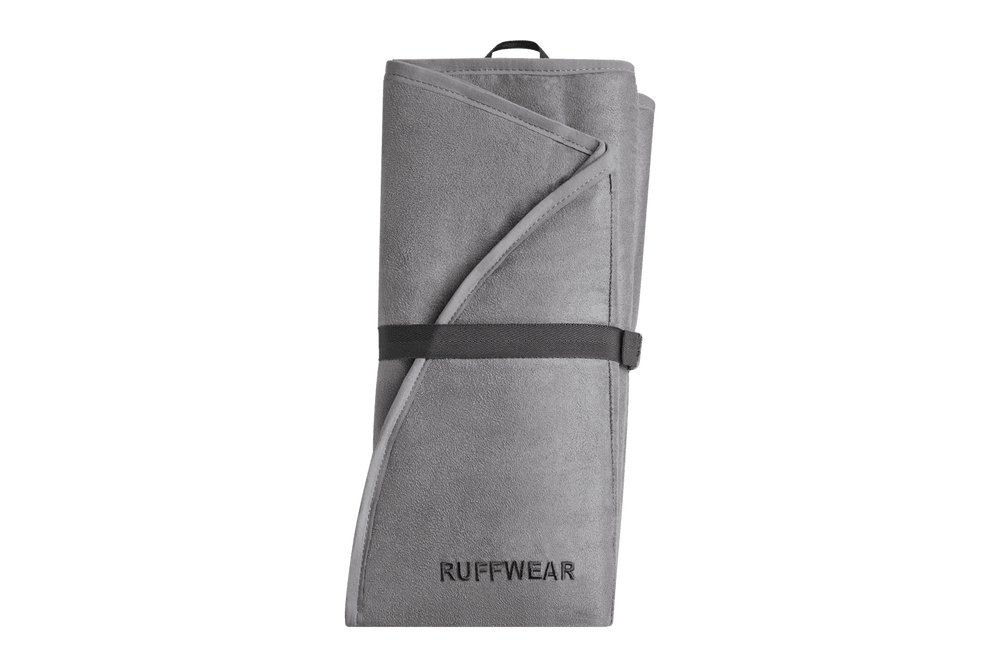 Faltbare graue Hunde-Isomatte von Ruffwear, zusammengerollt und mit strap fixiert. Ideal für Outdoor-Abenteuer mit Hund.