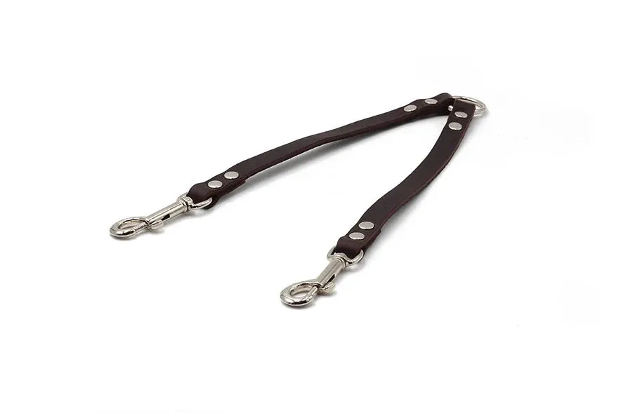 Doppeltes Hundehalsband aus braunem Leder mit silbernen Karabinerhaken für zwei Hunde sichern.