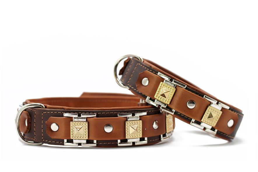 Zwei elegante Lederhalsbänder in Braun und Beige mit goldenen Nieten und einer robusten Silberschnalle.