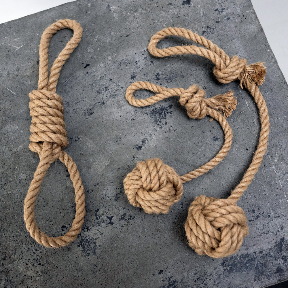 "Drei Hanfseile mit Knoten: einfaches Schlaufen-Knoten links und zwei doppelte Knoten mit Kugeln rechts."