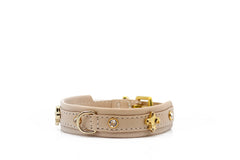 Beiges Lederhalsband mit goldenen Details und Lilien-Anhänger, verziert mit funkelnden Strasssteinen. Elegantes Design.