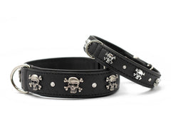 Schwarze Leder-Hundehalsbänder mit Totenkopf-Motiven und glänzenden Steinen, ausgestattet mit silbernen Schnallen.