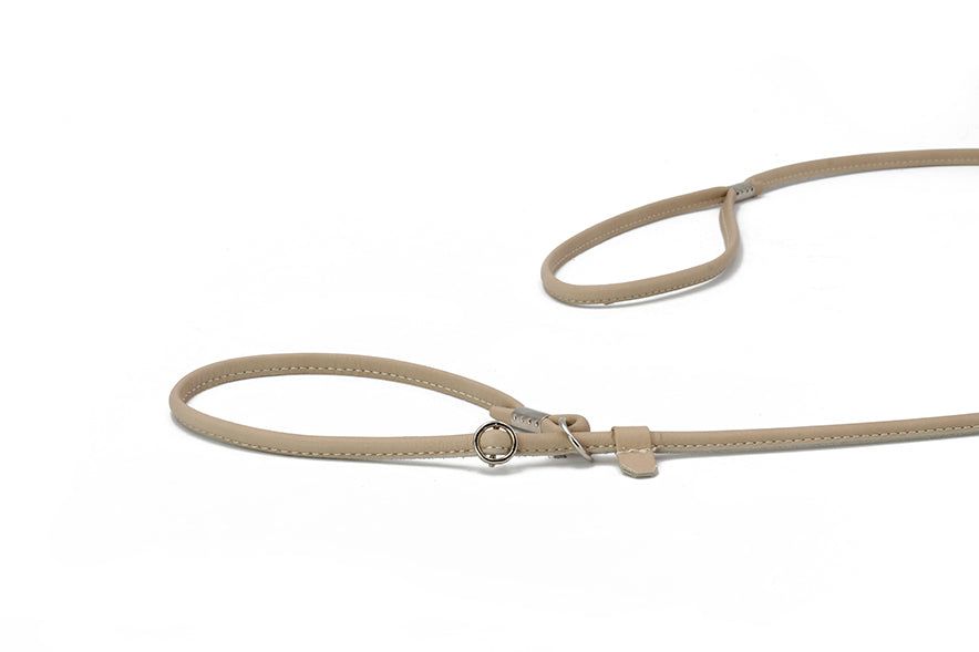 "Beige, feine verstellbare Hundeleine aus Leder mit zwei Schlaufen und Metallring für optimalen Komfort."