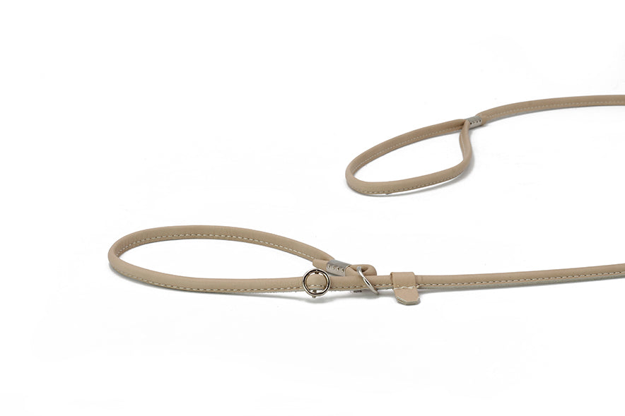 "Beige, feine verstellbare Hundeleine aus Leder mit zwei Schlaufen und Metallring für optimalen Komfort."