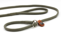 Schlanke, grüne Lederleine für Retriever mit Ringschluss und braunem, verziertem Anhänger. Ideal für Jagd und Spaziergänge.