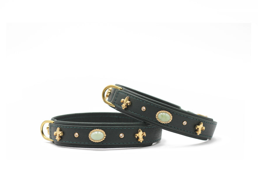 Zwei stilvolle Armbänder aus schwarzem Leder mit goldenen Verzierungen und ovalem Stein.