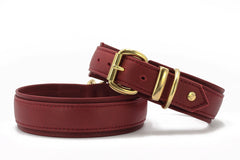 Zwei rote Ledergürtel: ein dickerer mit goldener Schnalle und ein schmalerer als schlichtes Accessoire.