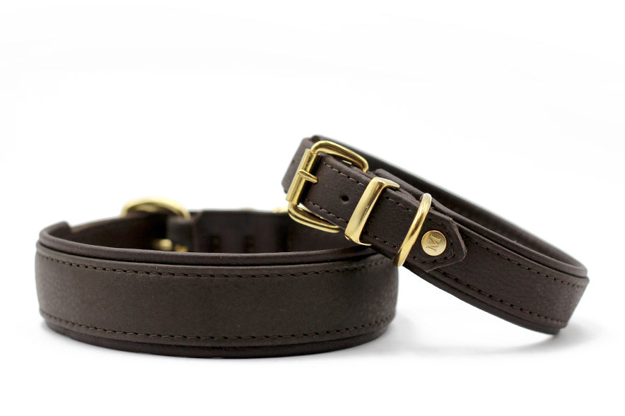 Zwei elegante braune Lederarmbänder mit goldenen Schnallen im klassischen Stil auf weißem Hintergrund.