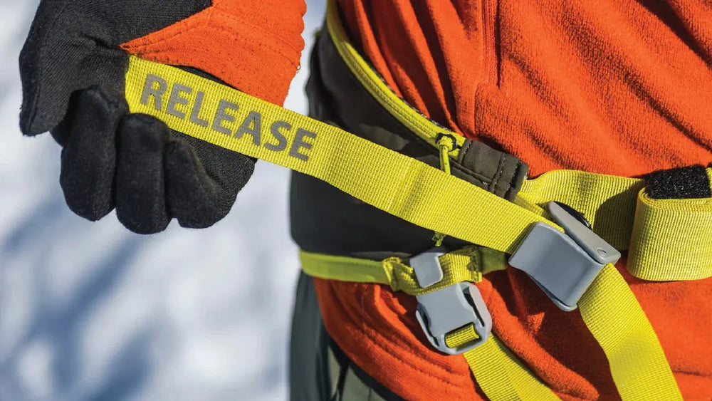 Person in orangefarbenem Fleece-Pullover zieht an einem gelben Sicherheitsgurt des Omnijore™ Hundejöringsystems.