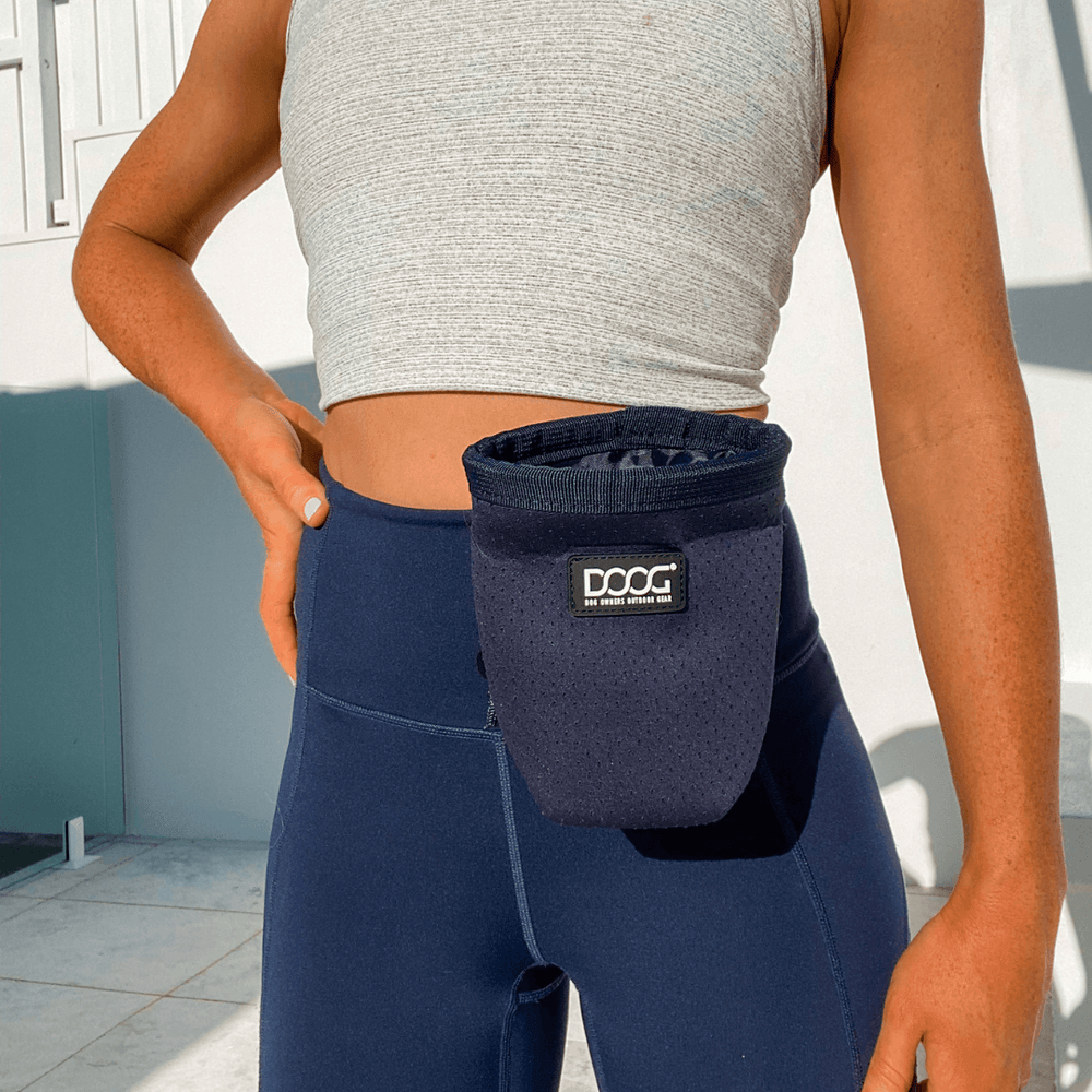 "Sportliche Person mit DOOG Treat & Training Pouch in hellem Umfeld, ideal für unterwegs."
