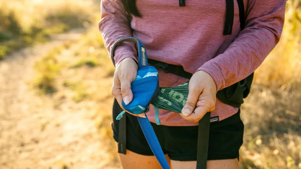 Person in Sportkleidung hält blauen Handgreifer zum Aufbewahren von Gegenständen beim Lauftraining.