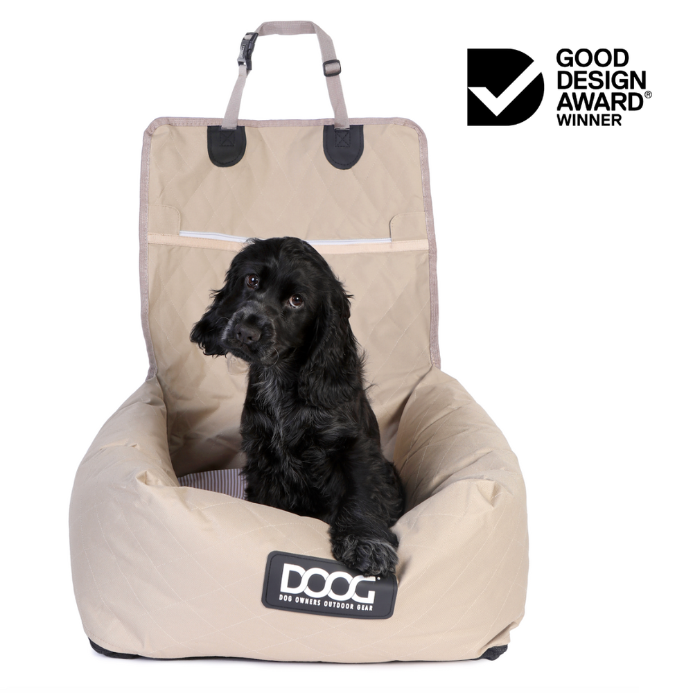 Beiges Hundebett mit gepolsterter Oberfläche und Haltegriff, ideal für sichere Autofahrten mit Hunden.
