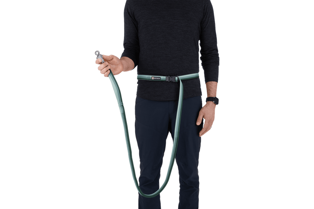 "Person mit Roamer™ Bungee-Hundeleine um die Taille, die sanfte Farben und Karabiner verbindet."