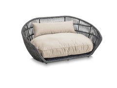 Elegantes ovales PRADO Design-Hundebett SMOOTH aus geflochtenem Material mit gepolsterter Sitzfläche und Rückenkissen.