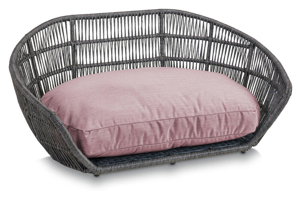 Gemütliches ovales Hundebett aus grauem Rattan mit rosafarbenem Kissen für stilvolle Haustier-Lounges.
