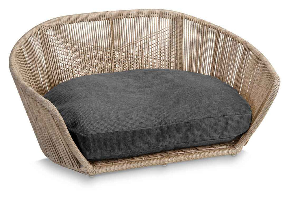 Modernes ovales Hundebett TUDOR aus hellem Rattan mit gepolstertem grauem Kissen im stilvollen VOGUE-Design.