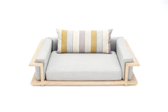 Modernes Hundebett Ascot Mahogany White mit hellem Stoff, Holzrahmen und gestreiftem Kissen in Gelb, Grau und Braun.