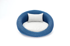 Rundes Hundebett Bellini mit blauen, geflochtenen Details, hellgrauem Sitzkissen und Rückenkissen, modern und gemütlich.