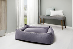 Gemütliches ORTHO Hundebett VITO in modernem Raum, weich gepolstert und grauer Stoff, neben minimalistischer Sitzbank.