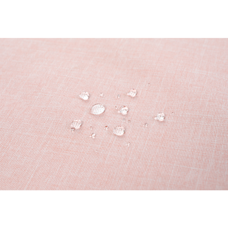 Rosa Stoffoberfläche mit klaren Wassertropfen, die die wasserabweisenden Eigenschaften demonstrieren.