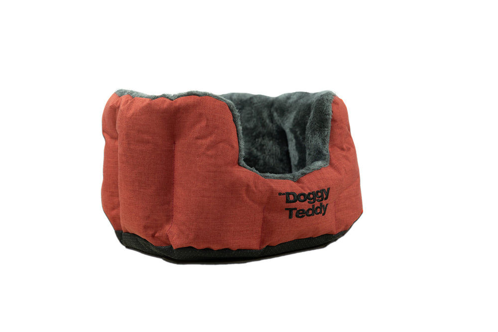 Rotes Haustierbett mit weichem grauen Innenfutter und ovaler Form, beschriftet mit "Doggy Teddy". Ideal für gemütliche Ruheplätze.