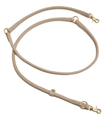Beige Leder-Hundeleine mit goldenen Karabinerhaken und Metallschlaufen, stilvoll und elegant für modebewusste Hundebesitzer.