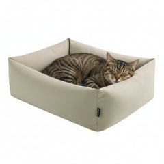 "Gemütliches rechteckiges Katzenbett 'NELU' in hellbeigem Stoff mit schlafender getigerter Katze."