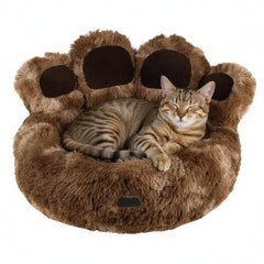 Komfortbett "Paw" in Pfotenform mit einer entspannten Katze auf der weichen, braunen Oberfläche. Ideal für Katzenliebhaber.
