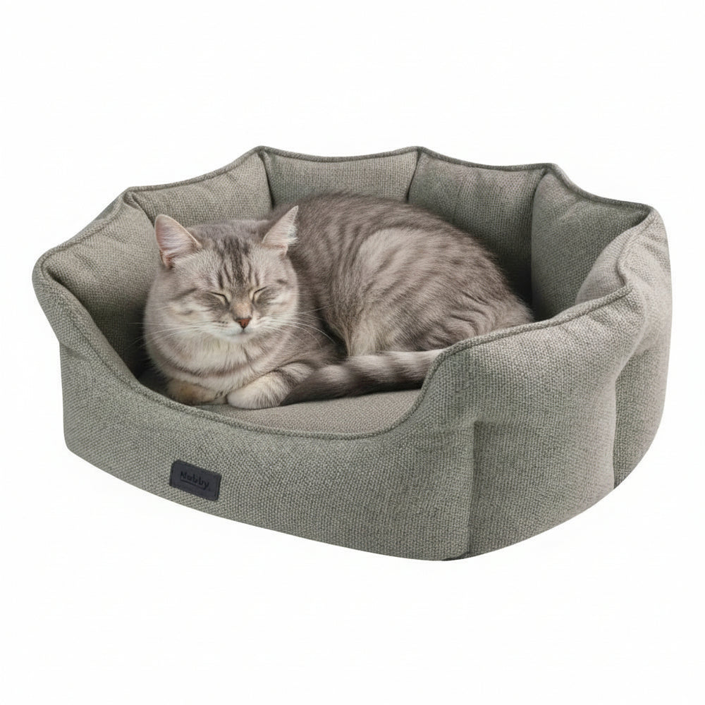Graues ovales Katzenbett "ANDA" mit weichem Rand, in dem eine entspannte graue Katze liegt.