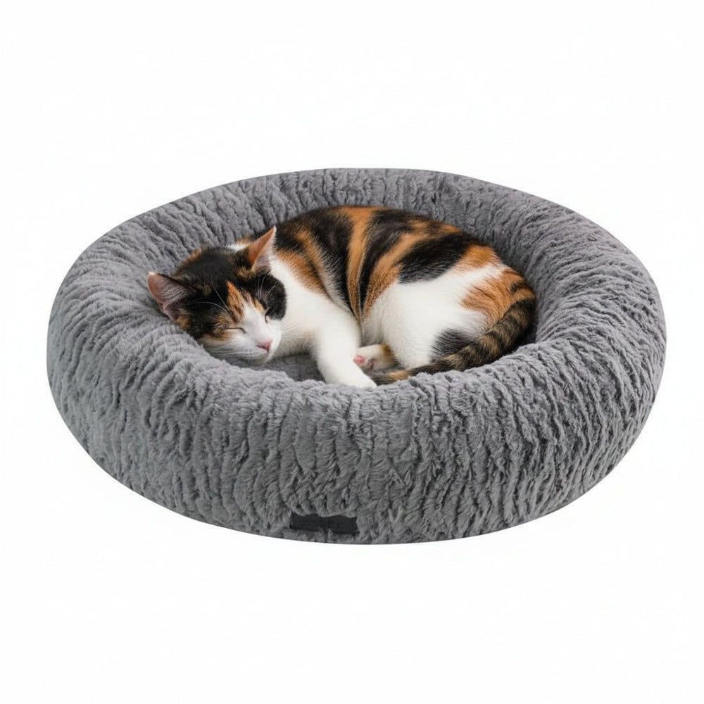 Rundes graues Katzenbett "NOVA" mit schlafender dreifarbiger Katze, weich und plüschig für optimalen Komfort.