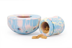 Pastellfarbene Porcini™ Futterbehälter für Haustiere, einer aufrecht, der andere mit Keksen auf der Seite.