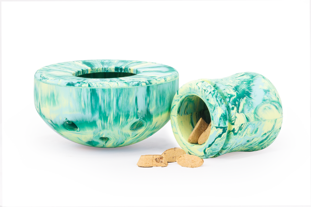 "Mehrfarbige Hunde-Spielzeuge aus Kunststoff in Grüntönen, einer steht aufrecht, der andere liegt umgekippt daneben."