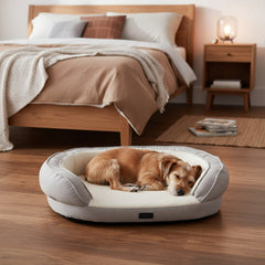 Beige ovales Hundebett "AMCA" mit schlafendem Hund im gemütlichen Schlafzimmer mit Holzfußboden.