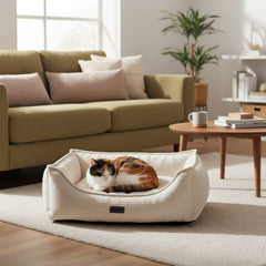 "Gemütliches eckiges Komfortbett 'KAMBA' mit entspannter Katze in heller Wohnumgebung."