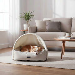 Kleiner Hund schläft gemütlich in ovalem Komfortbett "ILANA" mit Höhle in modernem Wohnzimmer.