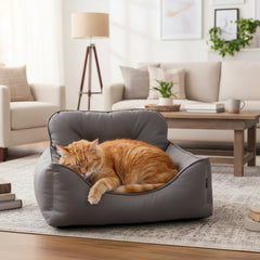 Gemütliches graues Katzenbett Enock mit einer schlafenden orangefarbenen Katze in modernem Wohnraum.