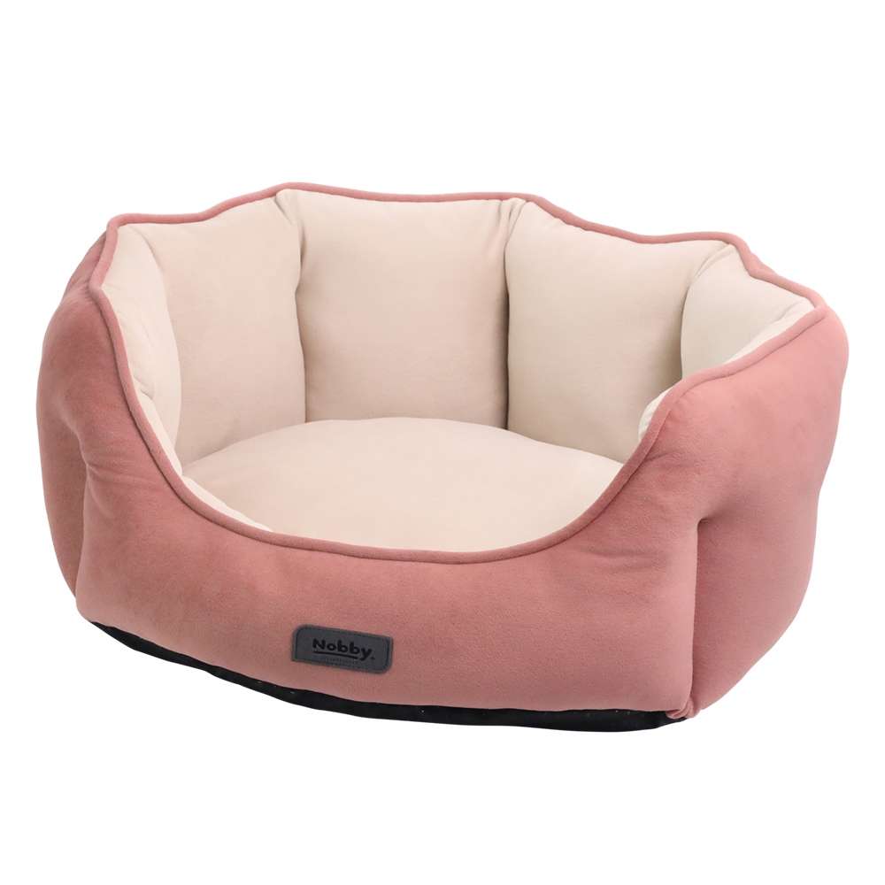 Komfortables ovales Kuschelbett „Majid“ für Hunde in weichem Beige und sanftem Rosa, ideal zum Entspannen.