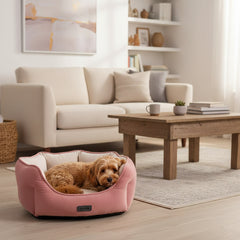 "Kuscheliges rosa Hundebett im Wohnzimmer mit hellem Sofa und Holztisch, ideal für entspannte Momente."