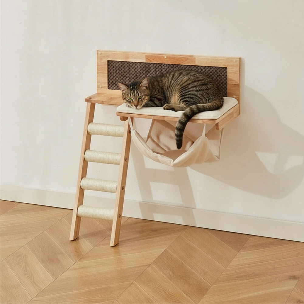 Katzenliege aus Holz an der Wand, mit gepolstertem Bezug und Stofftasche darunter. Ideal für entspannte Katzenmomente.