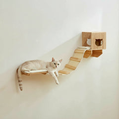 Hängende Katzenliege aus Holz mit entspannter Katze auf der Plattform und kleiner Hütte an der Wand befestigt.