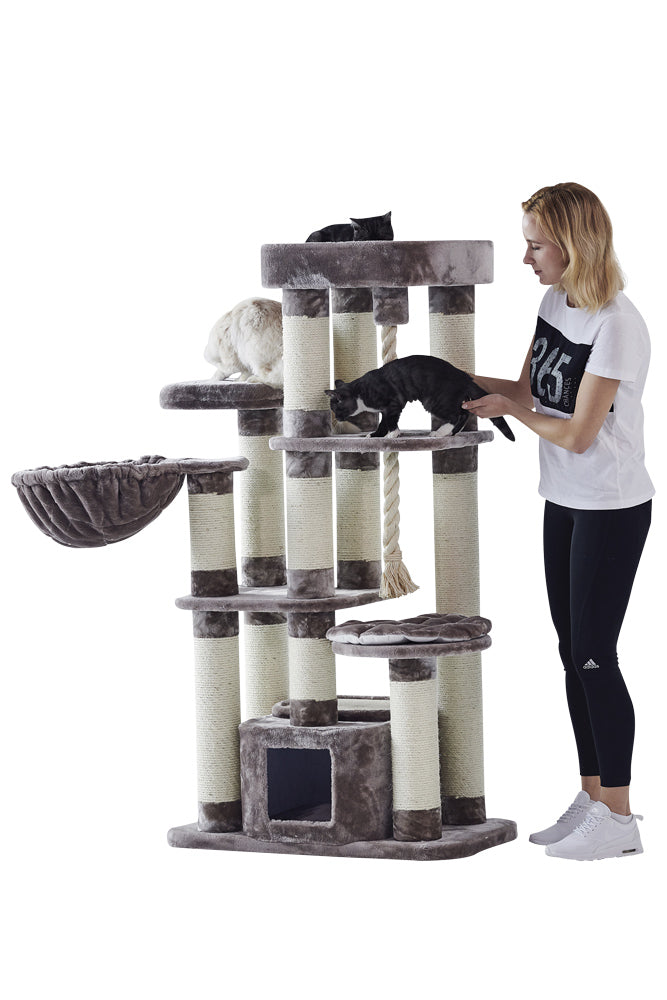 Großer Kratzbaum FREDO in neutralen Farben mit Hängematte, ideal für Katzen, Frau spielt mit Katze daneben.
