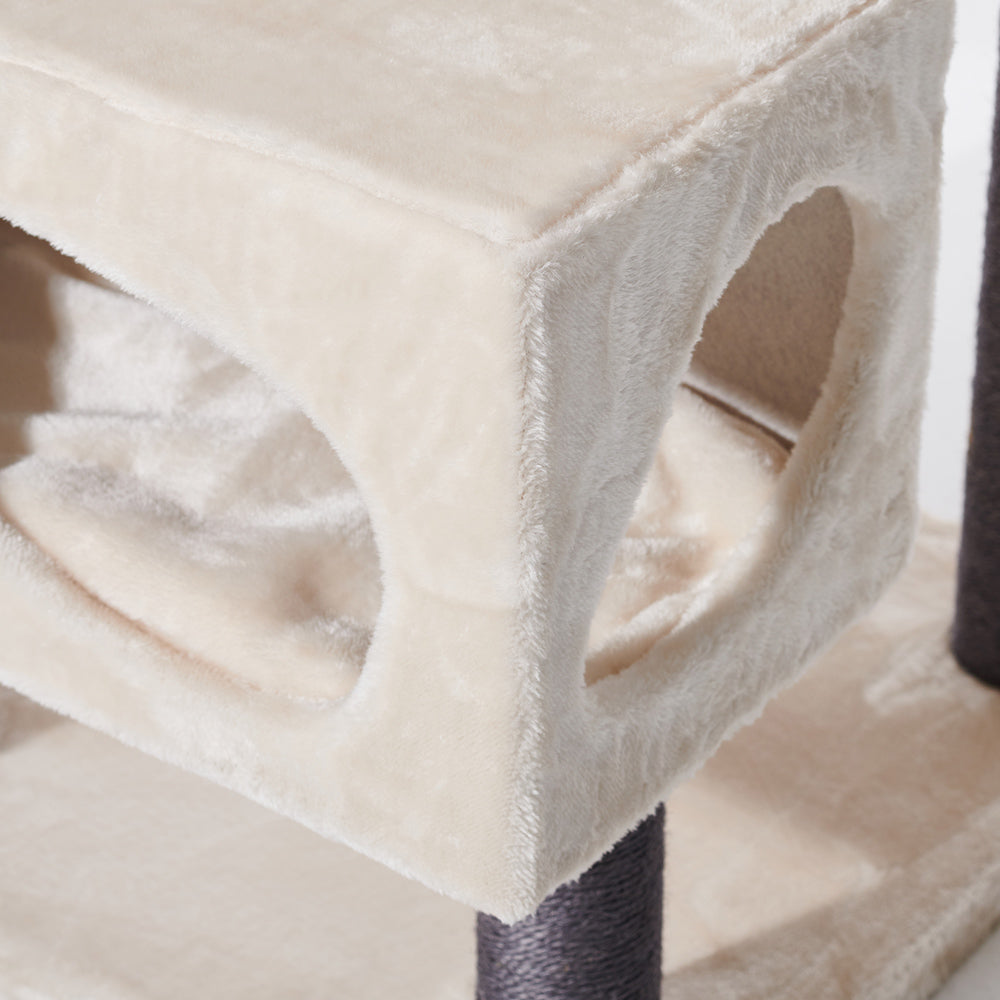 Beige Katzenhöhle auf Kratzbaum CORLU mit runden Eingängen und stabilen, dunklen Säulen für gemütliche Katzenmomente.