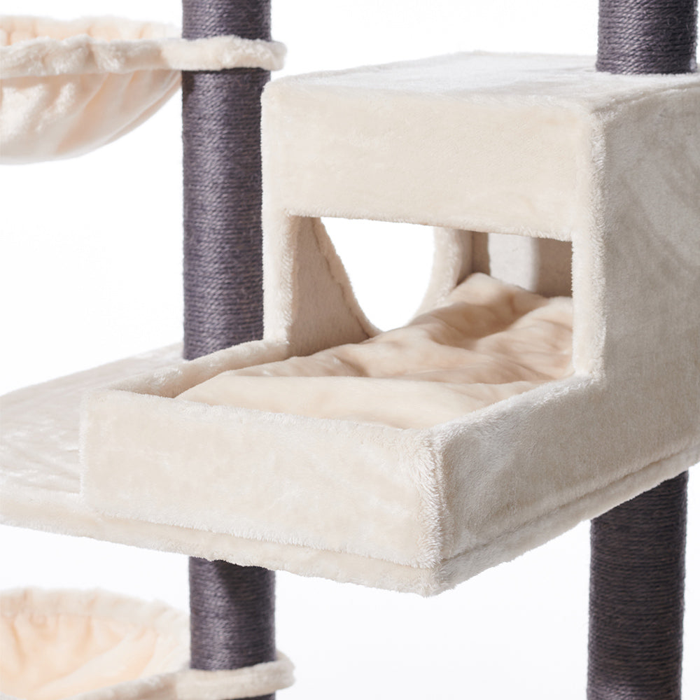 Kratzbaum CORLU mit gepolstertem Schlafplatz und Höhle für Katzen in cremefarbenem Design. Ideal für Entspannung und Spiel.