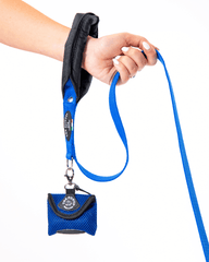 Blaue Hundeleine mit gepolstertem Griff und Beutel für Hundekotbeutel in der Hand gehalten.