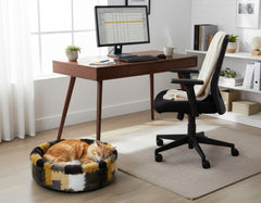 Gemütliches Arbeitszimmer mit Holzschreibtisch, Bürostuhl und schlafender orangefarbener Katze im runden Katzenkorb.