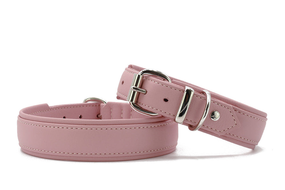 Zwei rosa Kunstleder-Gürtel im eleganten Design, einer mit Schnalle und auffälliger Naht, der andere glatt und breiter.
