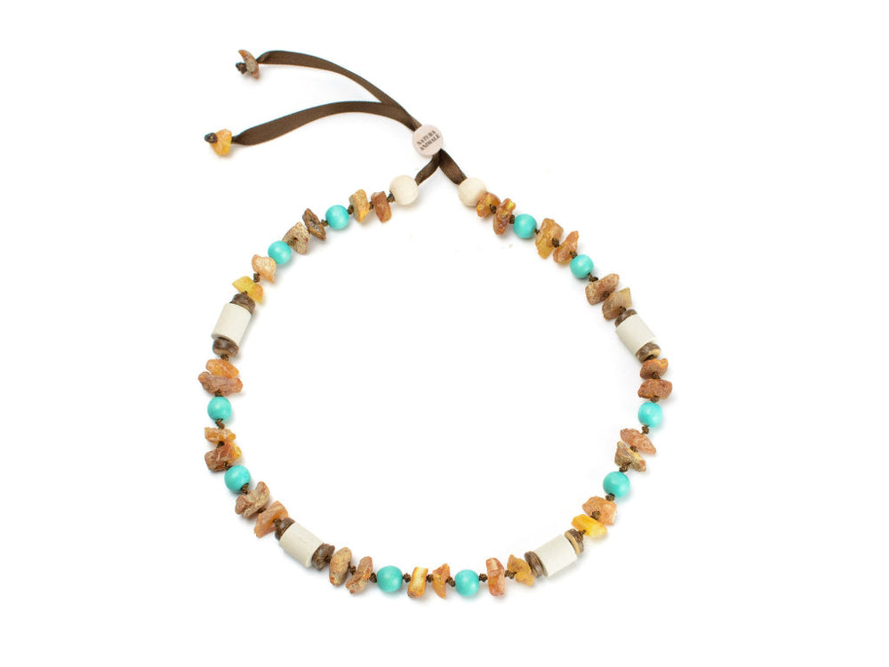 "Bernsteinkette Rosari mit naturbelassenen Braunstücken und bunten Perlen in Blau und Cremefarbe auf eleganter Schnur."