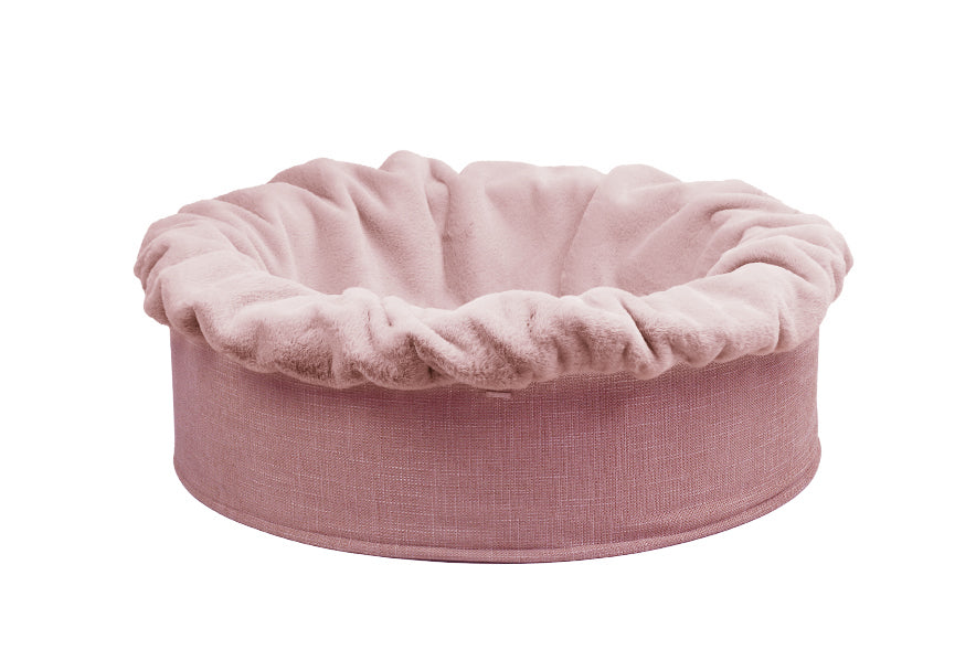 Rundes, gepolstertes Hundebett Buddelnest® in zartem Rosa mit gerüschtem Rand für gemütlichen Schlafplatz.